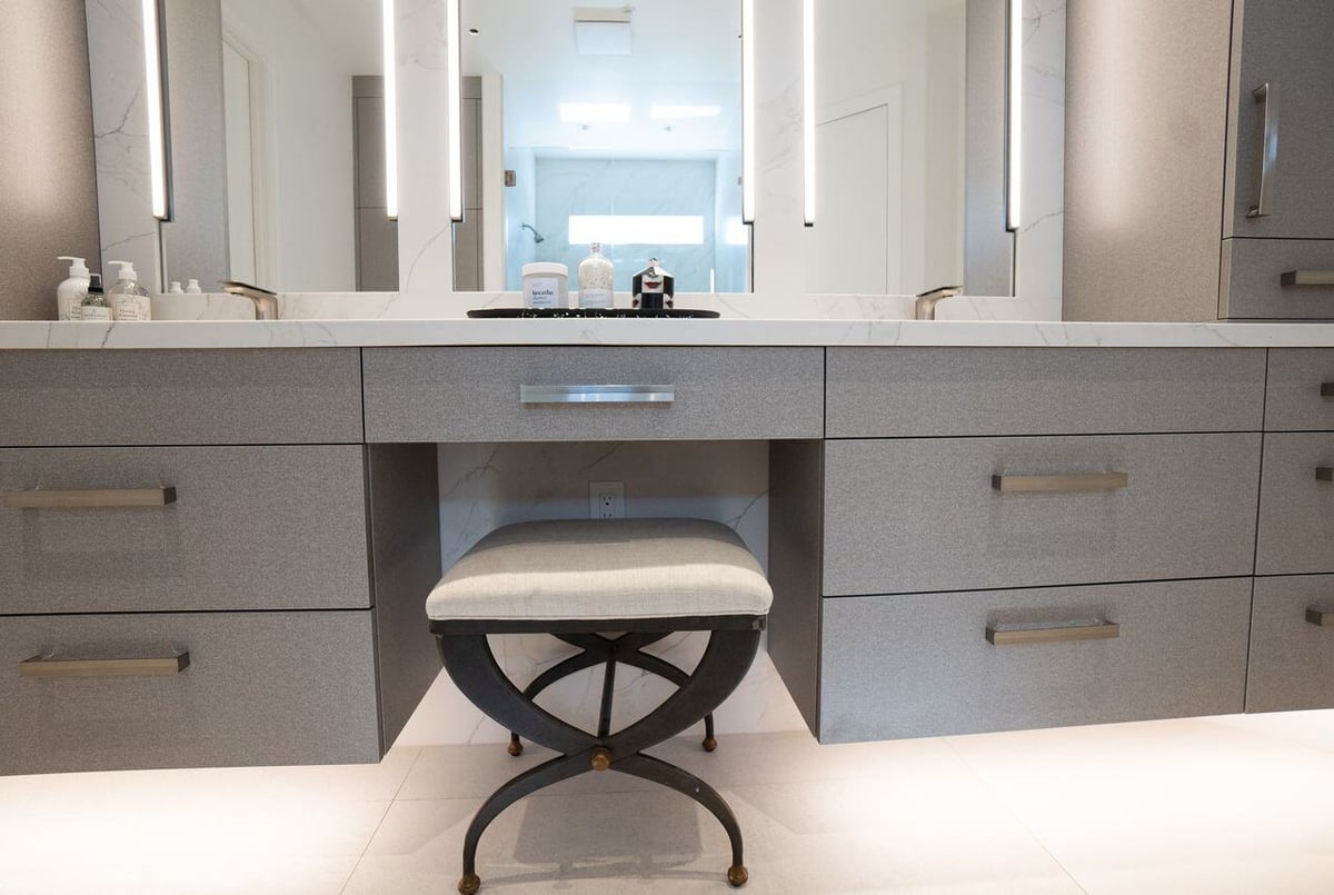 Floating vanity with custom cabinetry and backlit mirrors, part of a bathroom remodel by MGD Builders, Phoenix, AZ