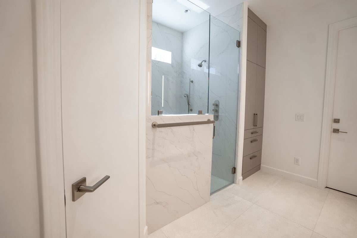 Luxurious bathroom featuring a glass-enclosed shower with marble accents, part of a remodel by MGD Builders in Phoenix, AZ