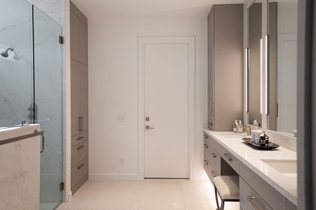 Modern bathroom with a glass-enclosed shower and sleek gray cabinets, remodeled by MGD Builders in Phoenix, AZ