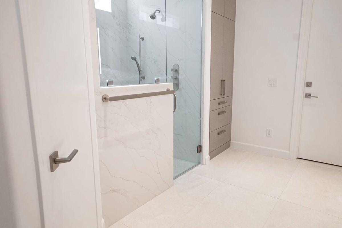 Modern bathroom with large walk-in shower and marble finishes, part of a remodel by MGD Builders in Phoenix, AZ