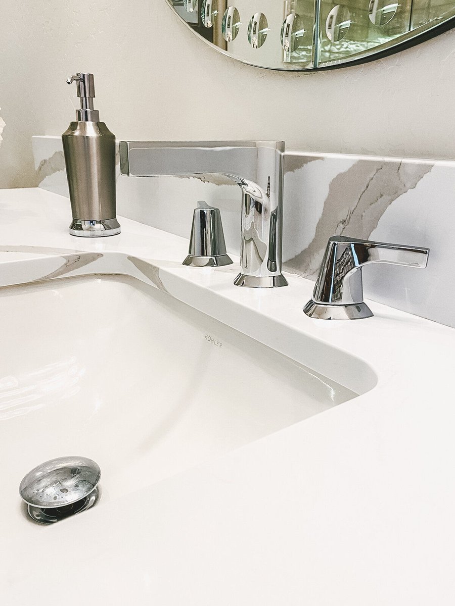 Chrome bathroom faucet and soap dispenser on a marble countertop, remodeled by MGD Builders in Phoenix, AZ