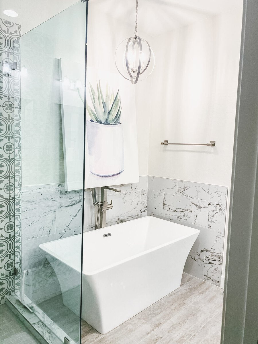 Freestanding white bathtub in a remodeled Phoenix, AZ master bathroom by MGD Builders