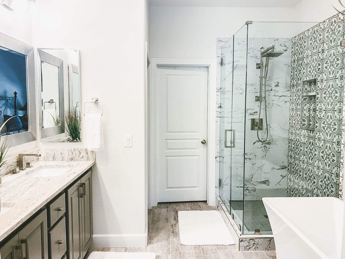 Glass shower and standalone bathtub in master bathroom remodel by MGD Builders in Phoenix, AZ