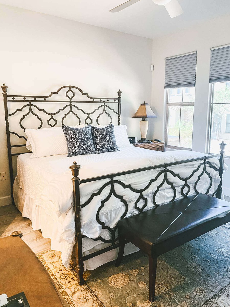 Iron-frame king-size bed in a remodeled bedroom, part of an MGD Builders project in Phoenix, AZ