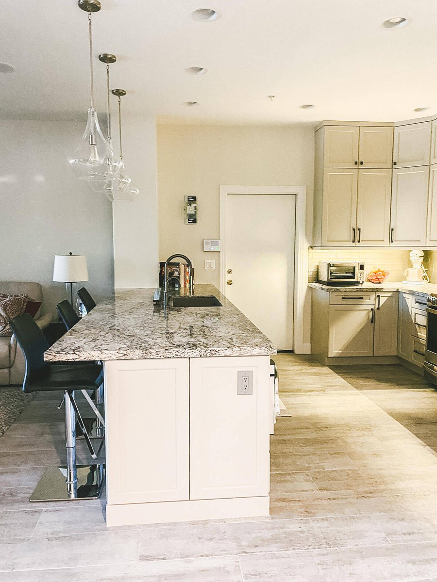 Modern kitchen island with granite countertop and bar stools, remodeled by MGD Builders in Phoenix, AZ