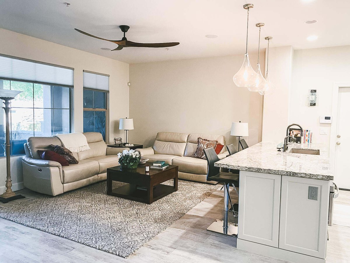 Spacious living room with beige furniture and granite kitchen island in Phoenix, AZ remodel by MGD Builders