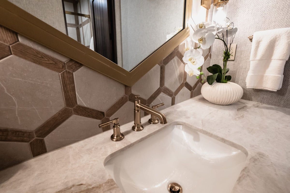 Custom bathroom with geometric tile backsplash and gold fixtures in Phoenix renovation by MGD Builders 