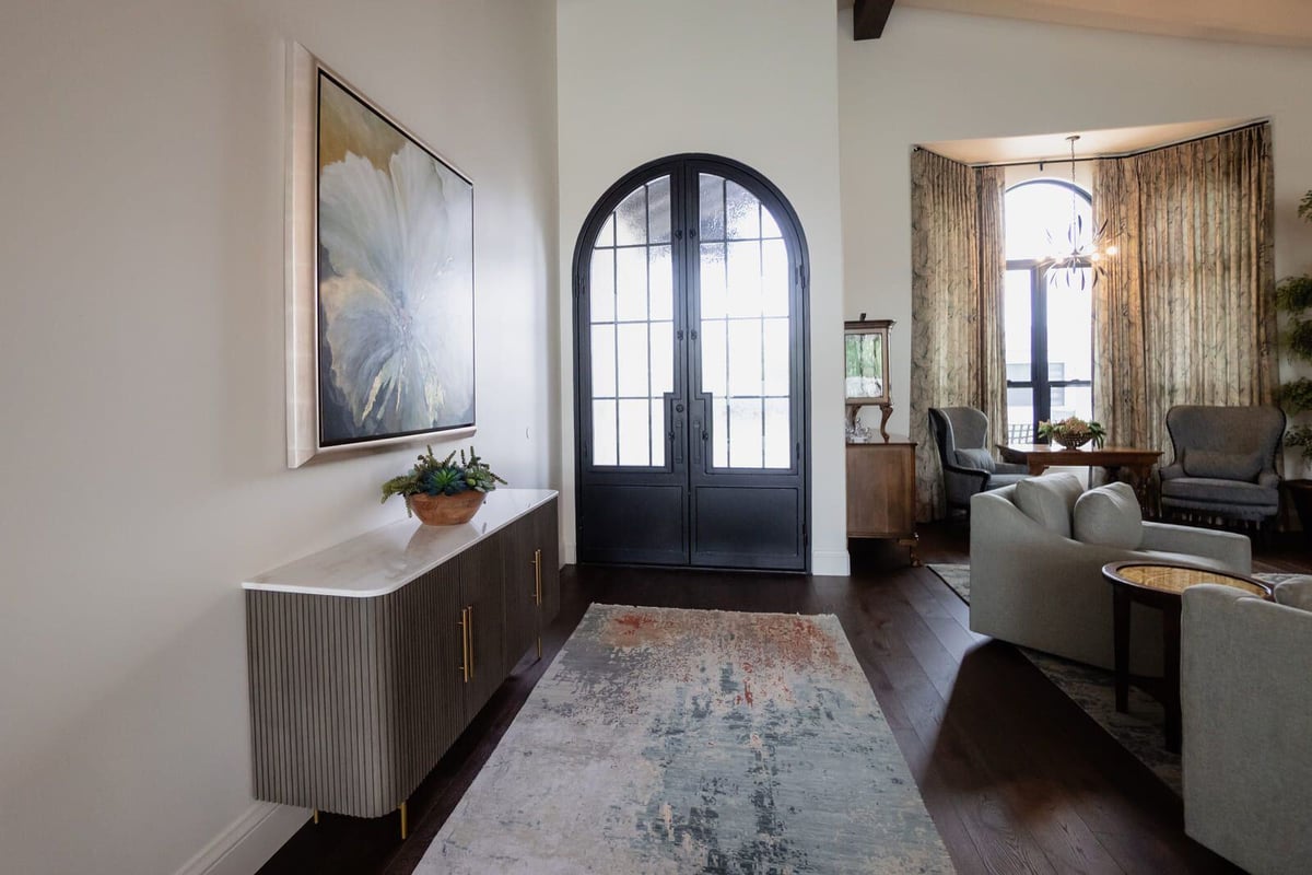 Custom home entryway featuring black arched doors and wall art, MGD Builders, Phoenix AZ 