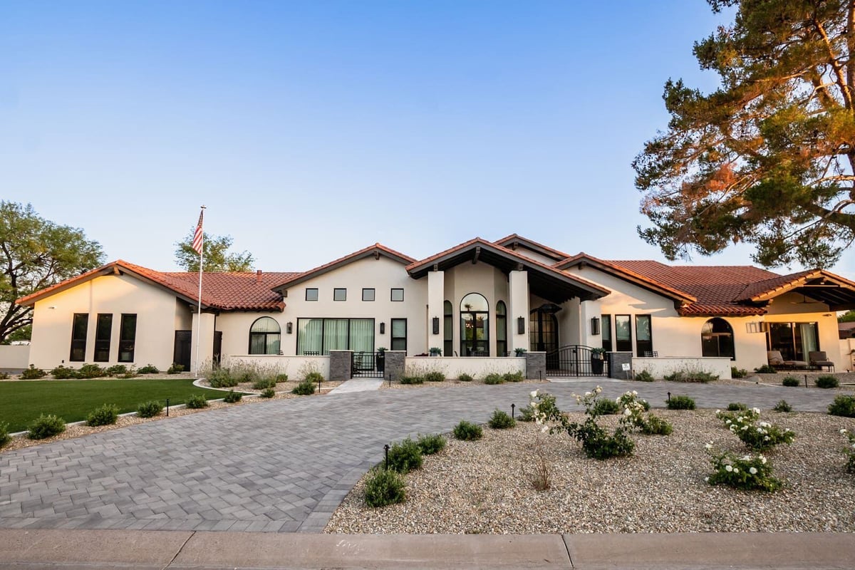 Front view of a modern home renovation with lush landscaping and driveway by MGD Builders in Phoenix, AZ 