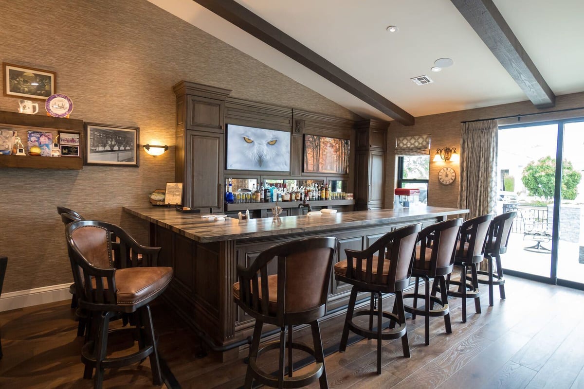 Home bar with leather stools and built-in shelves, part of a whole home renovation by MGD Builders in Phoenix, AZ 