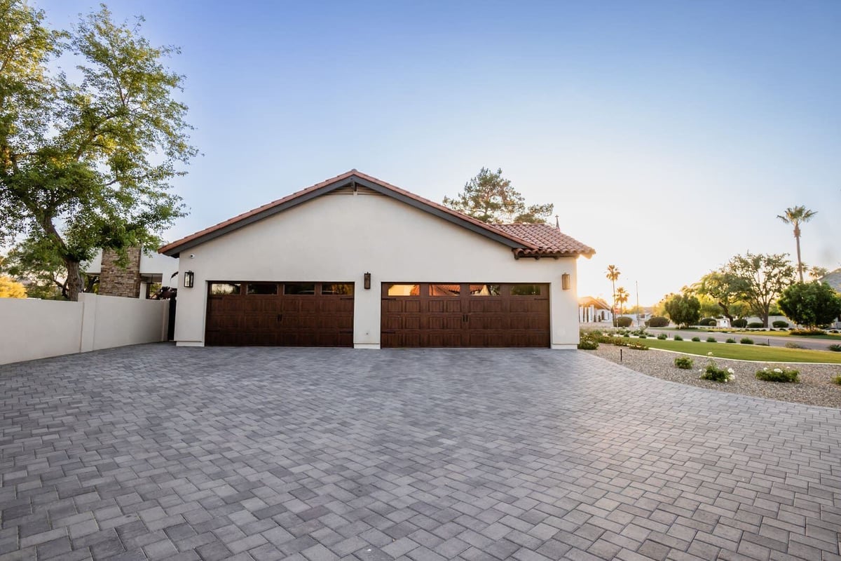 Large paved driveway leading to a modern garage as part of a home renovation by MGD Builders in Phoenix, AZ 