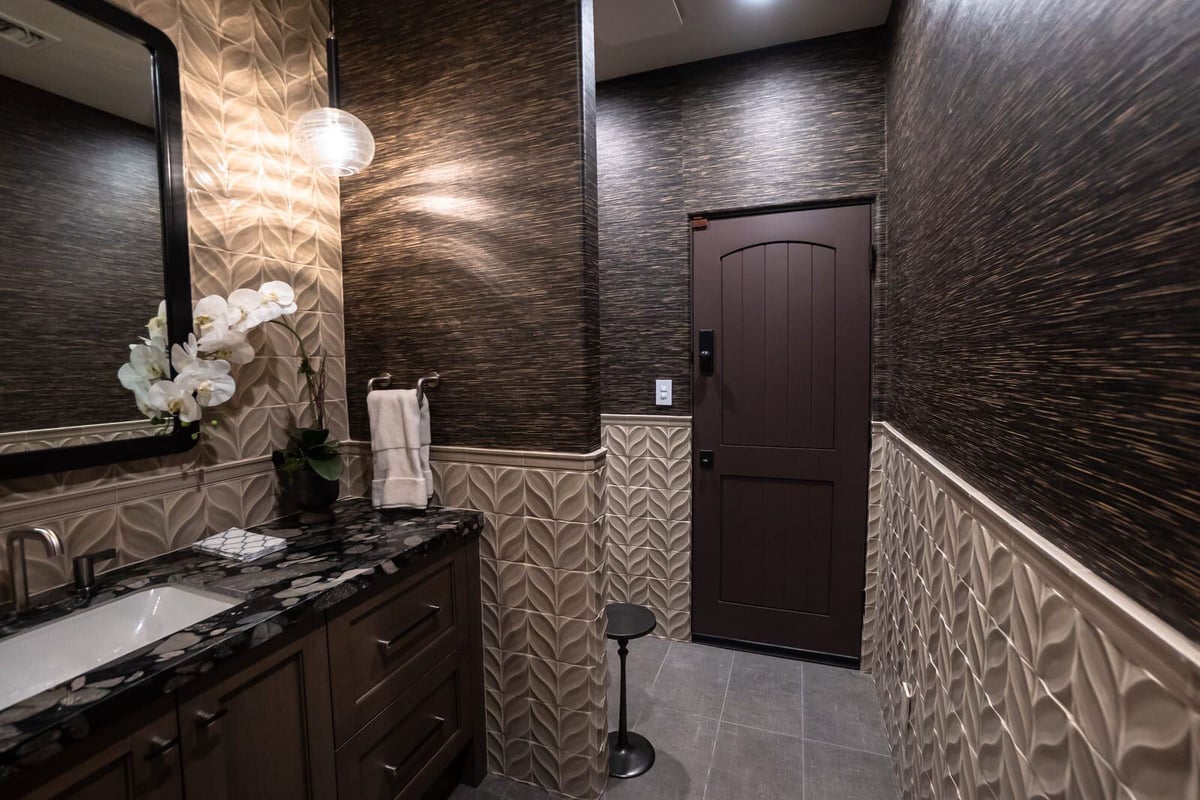 Luxurious bathroom with black counter, large mirror, and textured tile walls, MGD Builders, Phoenix AZ 