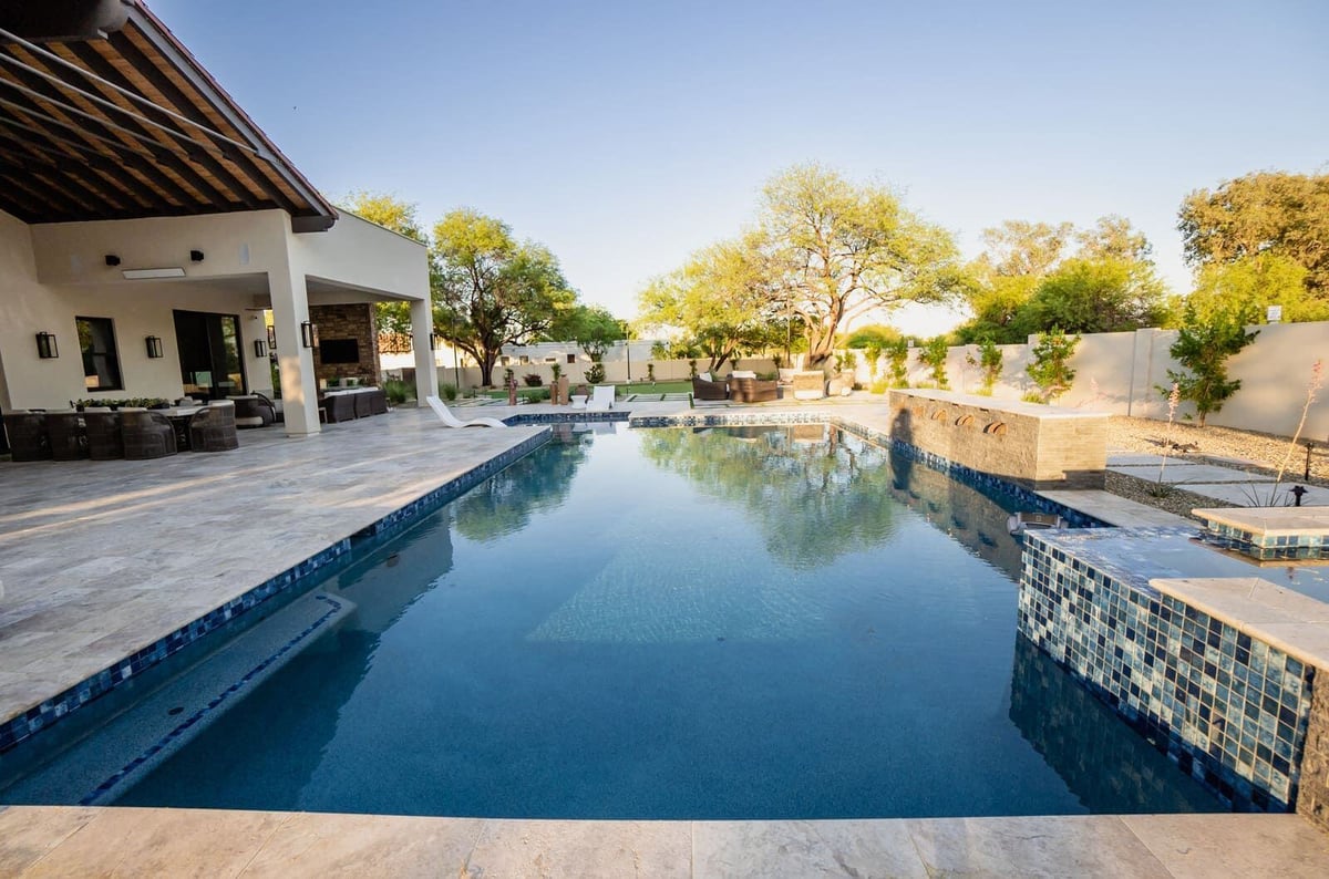 Modern outdoor living area featuring a pool and covered seating space, MGD Builders, Phoenix AZ 