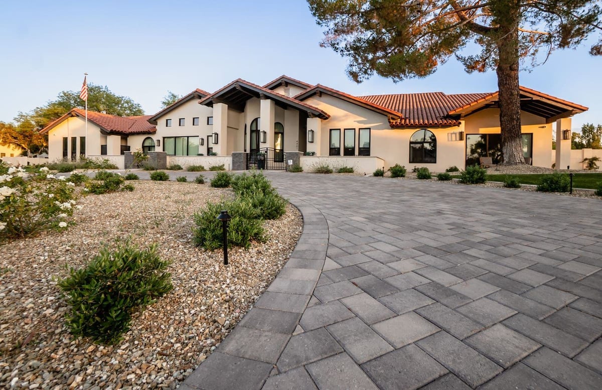 Newly renovated modern home exterior with landscaped yard and paver driveway in Phoenix, AZ by MGD Builders 