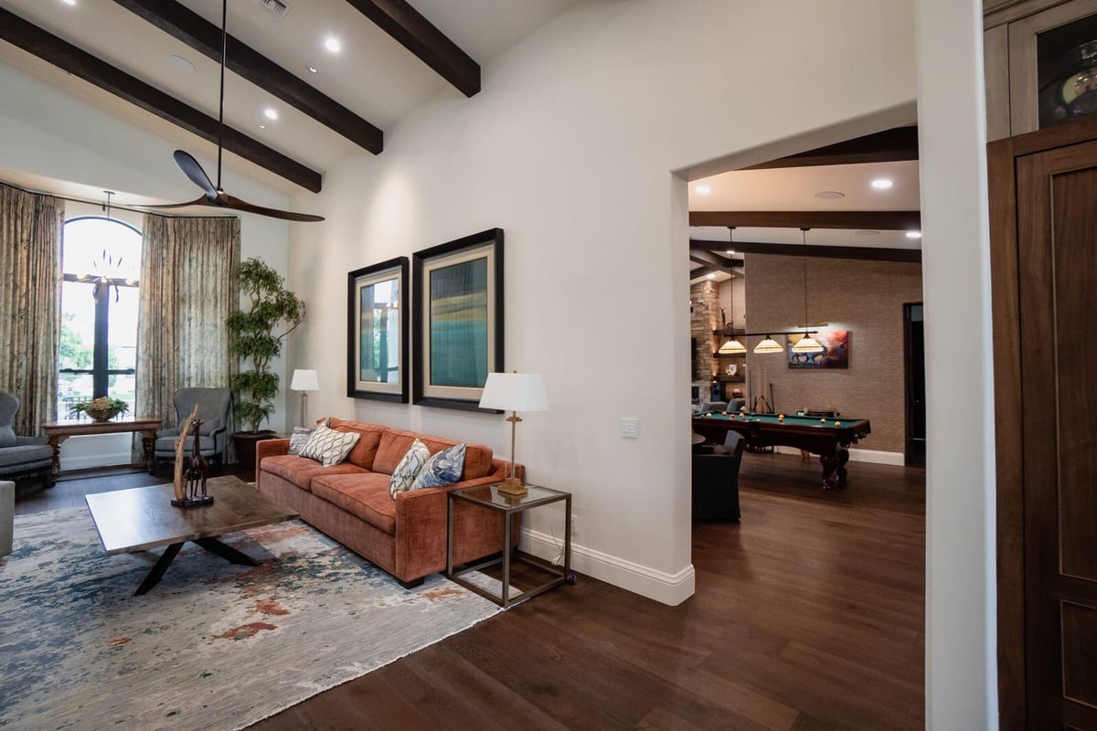 Open living area with high ceilings, orange sofa, and view into game room, Mertel Whole Home Renovation, MGD Builders, Phoenix AZ 