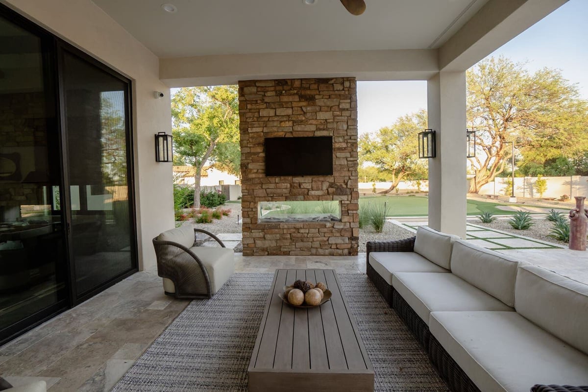 Outdoor covered patio with stone fireplace and cozy seating area, MGD Builders, Phoenix AZ 