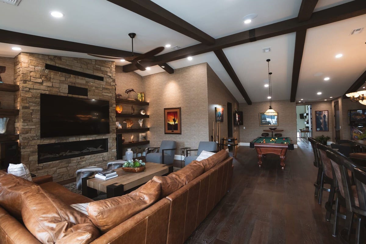 Phoenix home renovation featuring a living room with a stone fireplace and modern entertainment setup by MGD Builders 