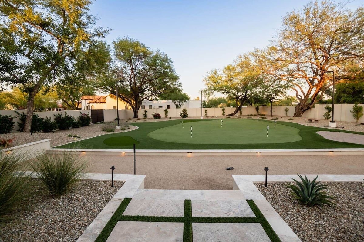 Renovated backyard with putting green and desert landscape in Phoenix, AZ by MGD Builders 